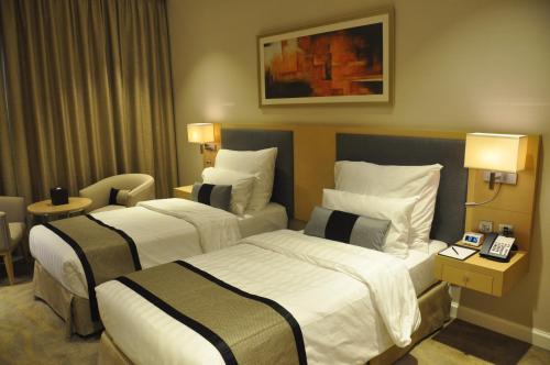 a hotel room with two beds in a room at Lavender Hotel Al Nahda Dubai in Dubai