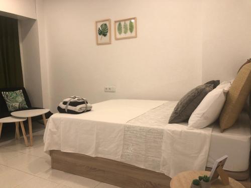 een slaapkamer met een bed, een tafel en een stoel bij Apartamento City & Sun in Alicante