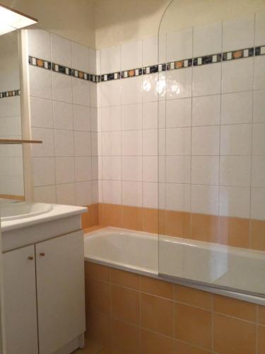 ein Badezimmer mit Badewanne und Waschbecken in der Unterkunft Vallon 3 pièces avec balcon in Trouville-sur-Mer