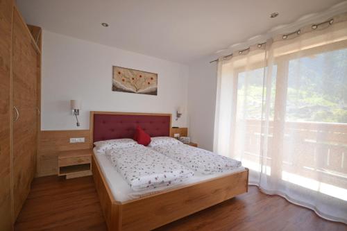 a bedroom with a bed and a large window at Residence Apartment Talblick in San Leonardo in Passiria