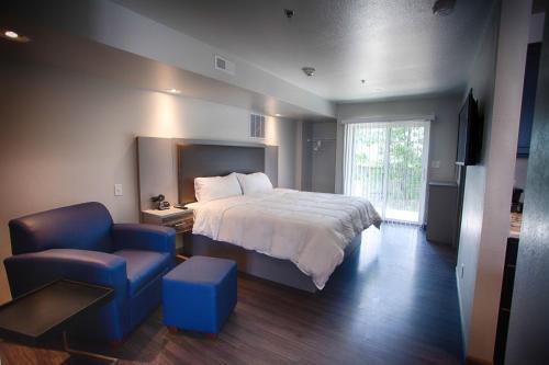 um quarto com uma cama e uma cadeira azul em Z Loft Extended Stay Hotel em Saint Robert