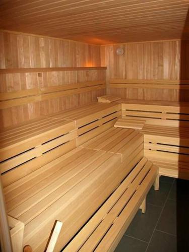 a empty sauna with wooden benches in a room at Villa De Meere Whg 8 in Nieblum