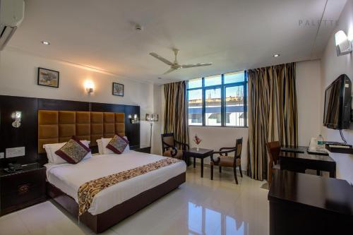 a hotel room with a bed and a desk at Raj Residency in Hosdrug