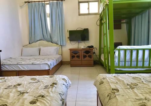a room with two beds and a flat screen tv at Fu Yuan B&B in Magong