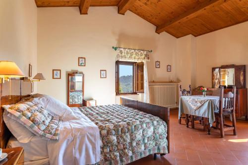 1 dormitorio con 1 cama y 1 mesa en Villa La Cappella, en Monticiano