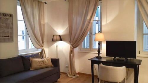 - un salon avec un canapé et un bureau avec une télévision dans l'établissement Barbacan Boutique Hotel, à Trieste
