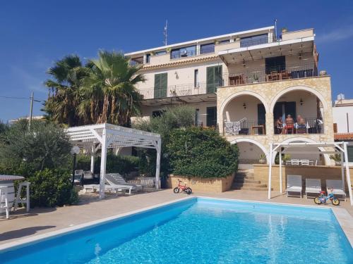 Villa con piscina frente a un edificio en Villa Ceni - Appartamenti con camere, cucina, wc e terrazza sul mare in villa con piscina, giardino e parcheggio, en Marinella di Selinunte