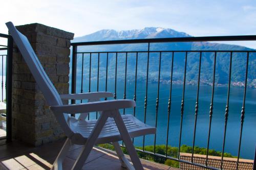 a blue chair sitting on a balcony overlooking the water at Residence Dorio in Dorio