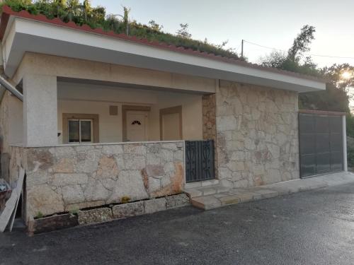 uma casa com uma parede de pedra e uma garagem em Casa Morgado em Braga