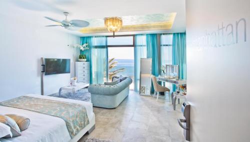 El Oceano Beach Hotel Adults only recommended في لا كالا ذي ميخاس: غرفة نوم مع سرير وغرفة معيشة مع طاولة