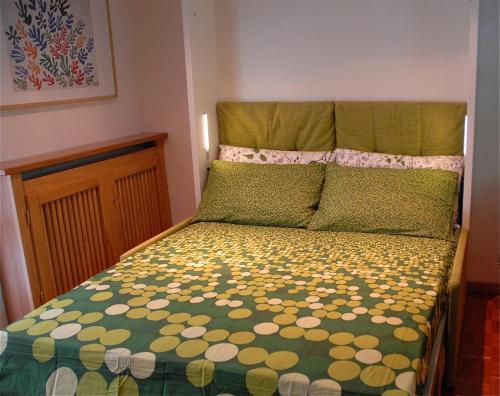 a bedroom with a bed with a green and yellow comforter at Oasi Budden 1 in Breuil-Cervinia