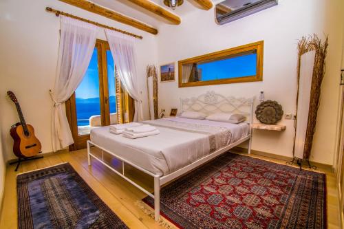 ein Schlafzimmer mit einem Bett und einer Gitarre darin in der Unterkunft East Crete Villa Mirabello in Kavoúsion