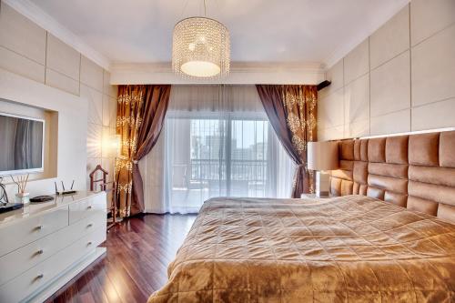 a bedroom with a large bed and a large window at Spacious family apartment on the Palm in Dubai