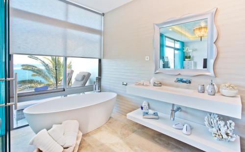 ein Badezimmer mit einer großen Badewanne und einem Spiegel in der Unterkunft El Oceano Beach Hotel Adults only recommended in La Cala de Mijas