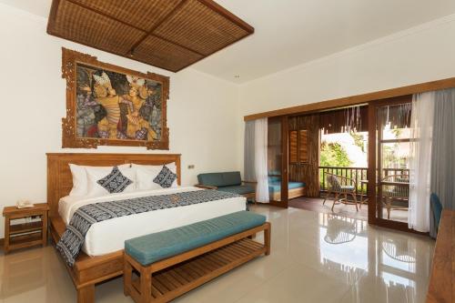 a bedroom with a king sized bed and a balcony at Bije Boutique & Gallery in Ubud