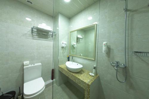 bagno con lavandino, servizi igienici e specchio di Sayyoh Hotel a Tashkent