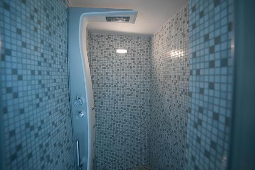 a bathroom with a walk in shower with blue tiles at B&B Al Duomo Molfetta in Molfetta