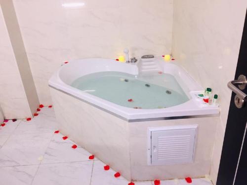 a white bath tub in a white bathroom at HOTEL DE LA VALLÉE in Chlef