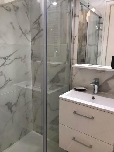 une salle de bain avec une douche en verre et un lavabo dans l'établissement Calme et Cosy appart proche plage quartier port, à Nice