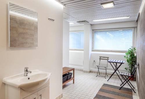 a bathroom with a sink and a table at Hotel Bulevard in Hanko