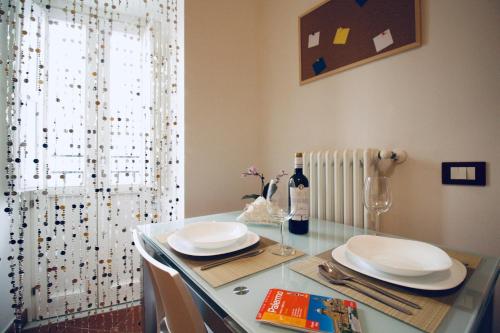 a dining room table with plates and glasses and a window at Casa vacanze Ai Corrieri in Palermo