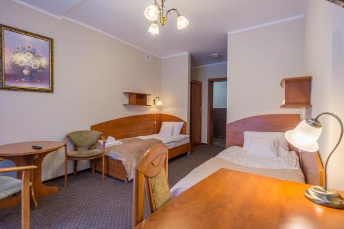 a hotel room with two beds and a desk at Hotel Diament in Szklarska Poręba