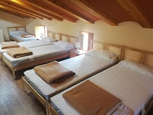 a group of four beds in a room at Casón Salto de Roldán in Sabayés