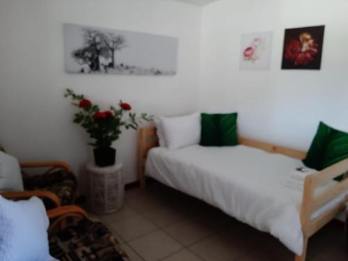 a bedroom with two beds and a plant on the wall at Rustverseker Self Catering Accommodation in George