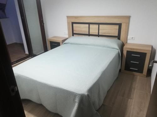 um quarto com uma cama branca e uma mesa de cabeceira em Apartamentos Buena Vista 4 em Coto Rios