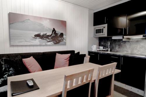 sala de estar con sofá y mesa en Kåppas Cabin Village en Björkliden