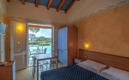 una camera da letto con un letto, un tavolo e un balcone di Park Gallanti a Lido di Pomposa