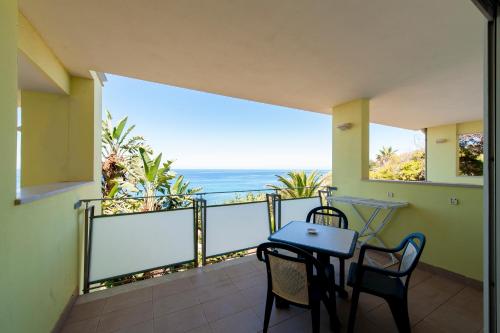 a balcony with a table and chairs and the ocean at Hotel Villaggio Stromboli in Santa Domenica