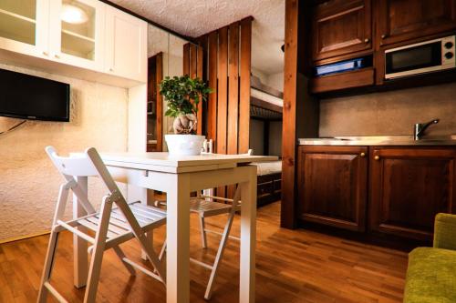 een keuken met een tafel en stoelen in een kamer bij oasi budden 2 in Breuil-Cervinia
