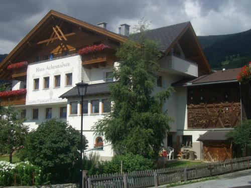 a large white building with a wooden roof at Haus Achenrainer in Fiss