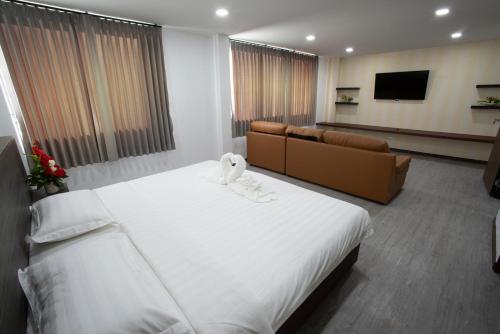 a hotel room with a large bed and a couch at NK Residence Sakon Nakhon in Sakon Nakhon