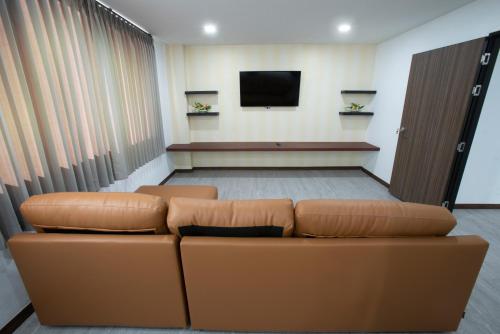 a waiting room with a couch and a tv at NK Residence Sakon Nakhon in Sakon Nakhon