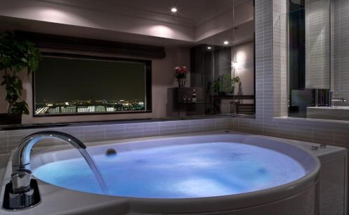 a large bath tub in a bathroom with a tv at Urayasu Brighton Hotel Tokyo Bay in Urayasu