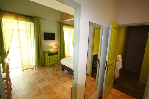 uma sala com um quarto com uma cama e uma televisão em Logis Hôtel Restaurant Le Domaine de l'Eau Vive em Largentière
