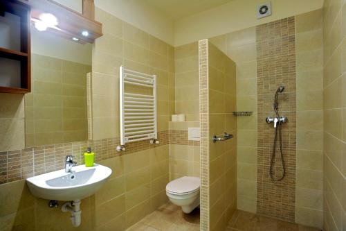 a bathroom with a sink and a toilet and a shower at Cserkeszem Panzió in Cserkeszőlő