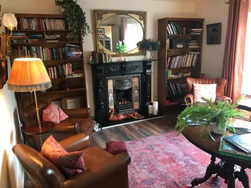 a living room with a fireplace and a table and chairs at The Happy Pig in Kenmare