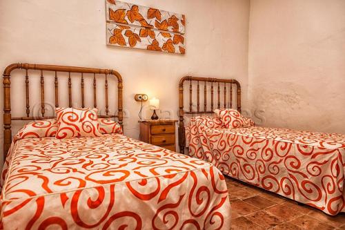 two beds sitting next to each other in a bedroom at Casa Rural Casa Máxima in Yecla