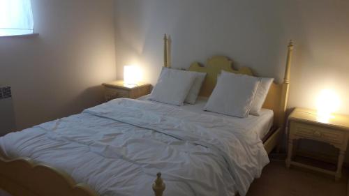 ブランケンベルヘにあるApartment Mirador 6のベッドルーム1室(白いシーツとランプ2つ付)