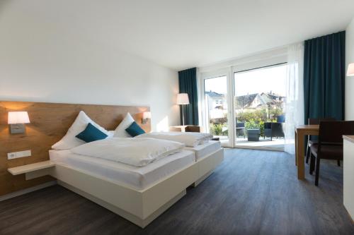a bedroom with a large bed and a balcony at Boardinghouse E68 in Schliengen