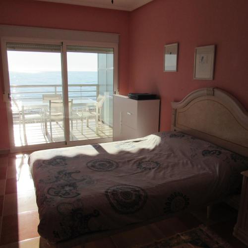 a bedroom with a bed with a view of a balcony at Edificio Montecarlo Playa San Juan in El Campello