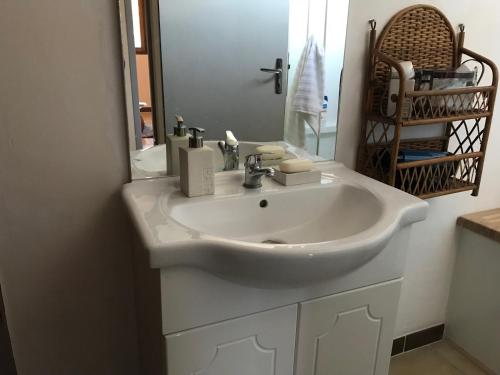 a white sink in a bathroom with a mirror at Maison 2Ch - 4 pers en Picardie parking gratuit - by La Source d'OrFée in Courcelette