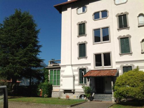 a white building with green shutters on it at Casa Mary Varenna in Varenna