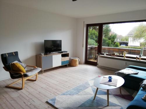 een woonkamer met een bank, een tv en een tafel bij Appartment-Harzallerliebst in Bad Sachsa
