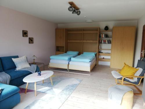 - un salon avec un canapé bleu et une table dans l'établissement Appartment-Harzallerliebst, à Bad Sachsa