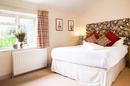 a bedroom with a white bed and a window at Banbury Hill Farm in Charlbury