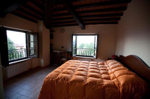 una camera da letto con un letto grande con due finestre di Le Rasse a Citerna